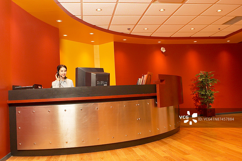 办公室大堂的接待员在桌子旁工作图片素材