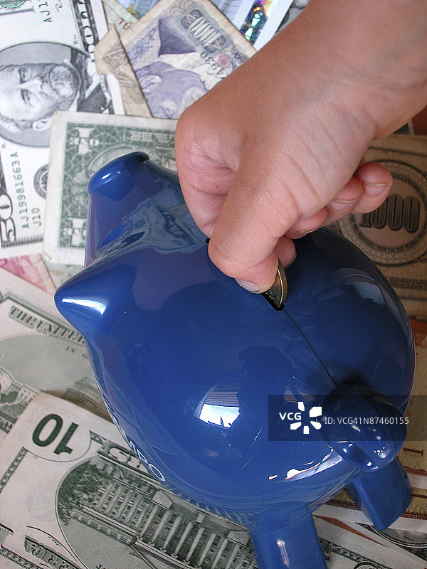 向小猪储蓄罐里投币图片素材