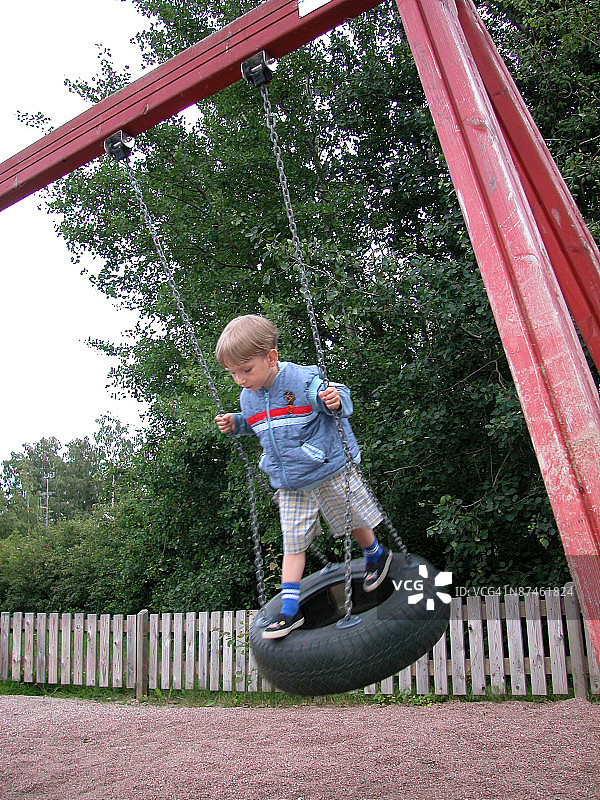 在轮胎秋千上的男孩图片素材