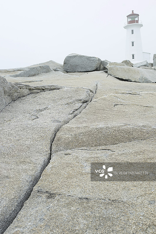 灯塔附近岩石岸边的旧小艇图片素材