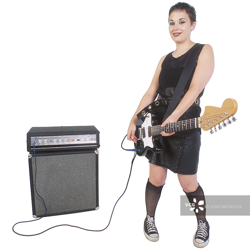 手持电吉他和放大器的女人图片素材