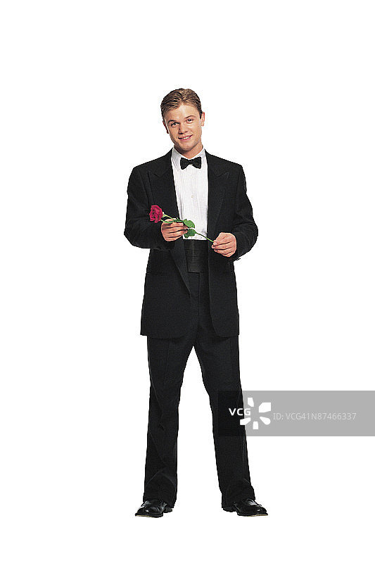 穿燕尾服戴玫瑰花的年轻男人图片素材