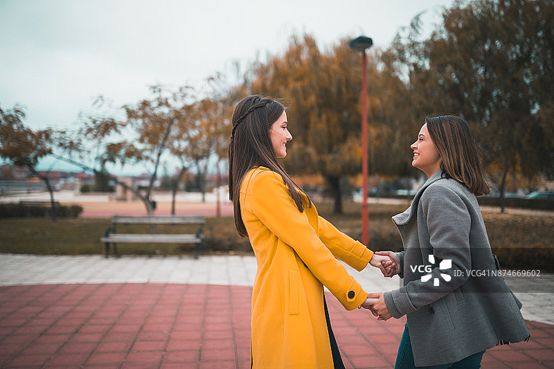 阳光明媚的公园里嬉戏的少女图片素材