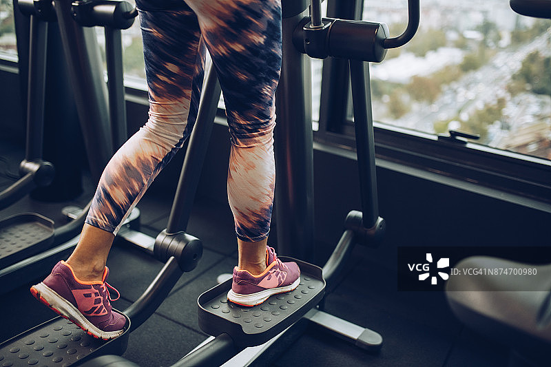 在健身房使用交叉训练机的运动员图片素材