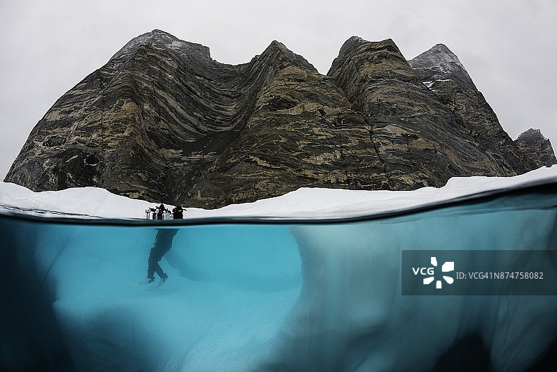 潜水员在东格陵兰岛斯科斯比松峡湾的冰山上自拍图片素材