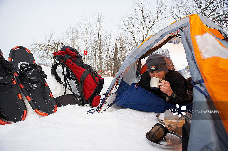男子在冬天帐篷里喝饮料图片素材
