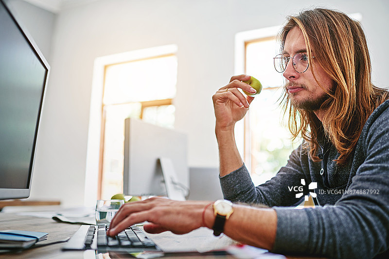 他喜欢在工作时吃健康零食图片素材