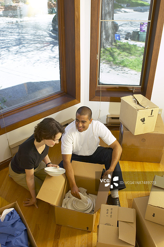 一对情侣在新公寓里拆包碗碟图片素材