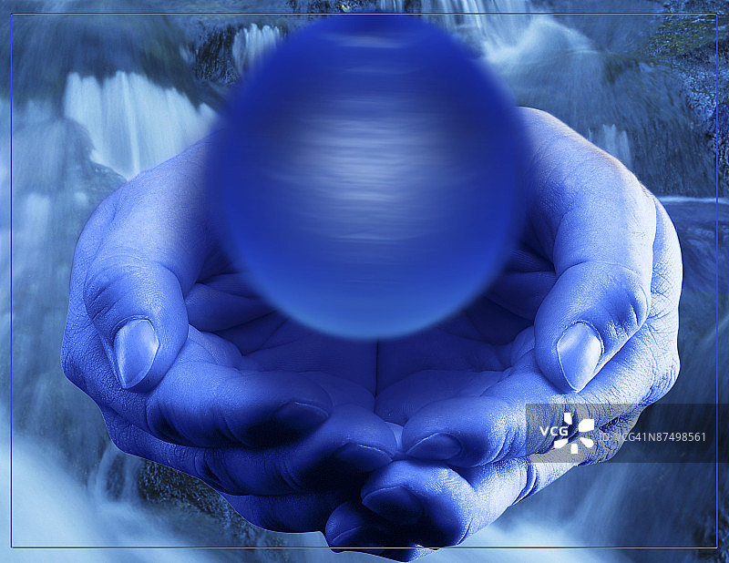 手持旋转蓝色球体的人图片素材