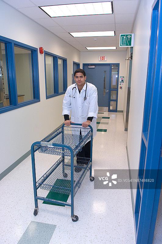 医生在医院走廊里推着手推车图片素材