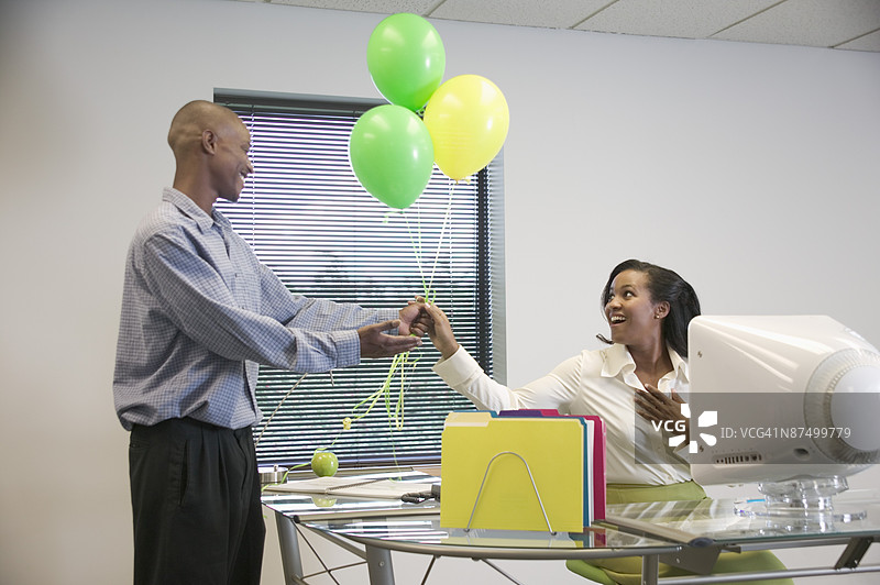 办公室里的男人与气球和鲜花图片素材