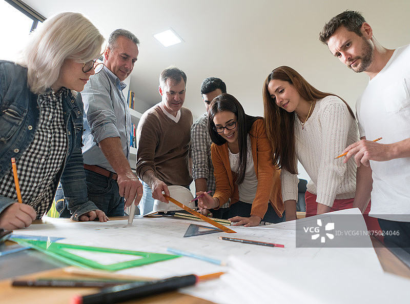 在会议上查看蓝图的一群建筑师图片素材