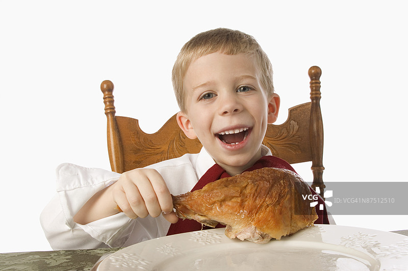 男孩在吃火鸡腿图片素材