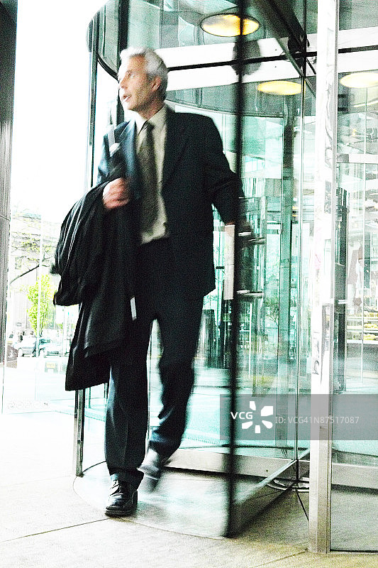 穿过旋转门的商人图片素材