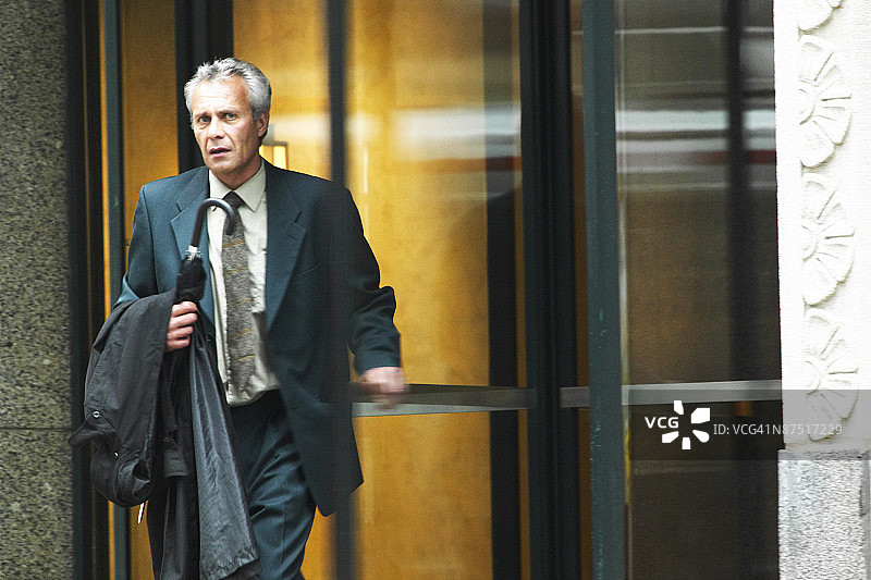 离开办公大楼的严肃商人图片素材