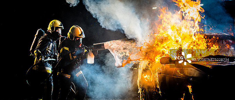 消防员向燃烧的汽车喷水图片素材