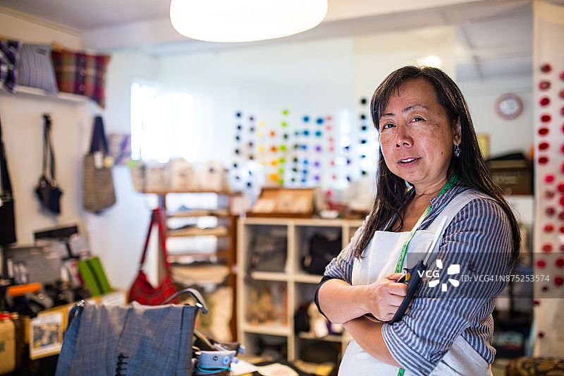 中年企业家在手工包店拿着数码平板图片素材