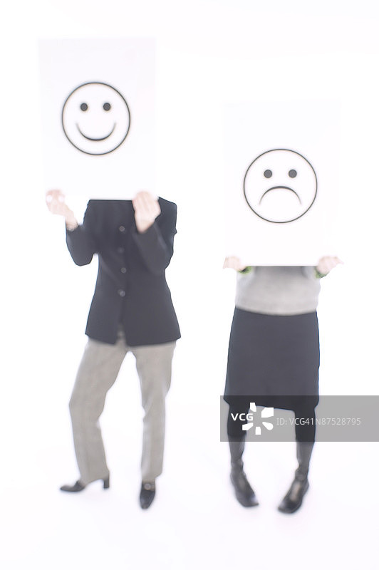 人们手持快乐和悲伤的标志图片素材