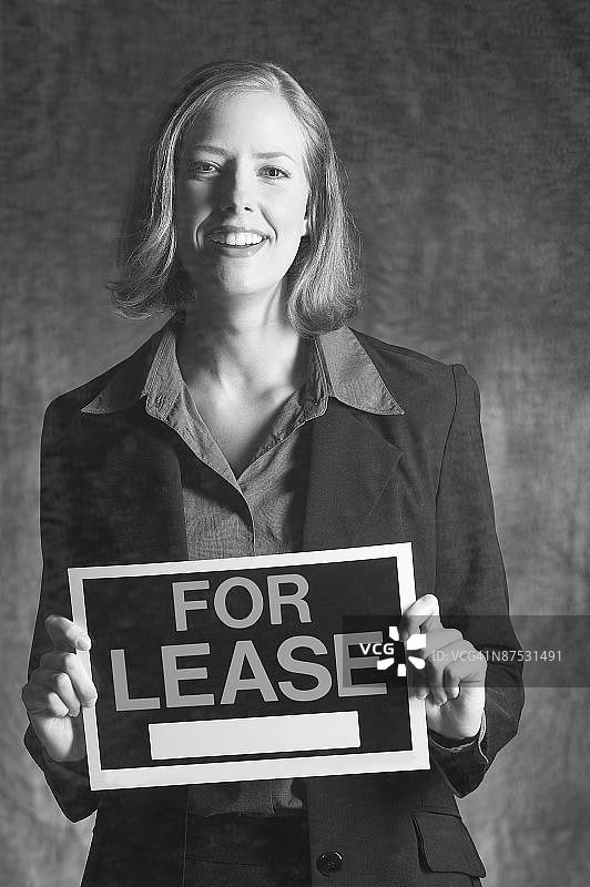 手持“出租”标志的房地产经纪人肖像图片素材