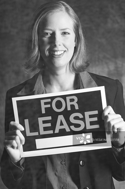 持有出租标志的房地产经纪人肖像图片素材