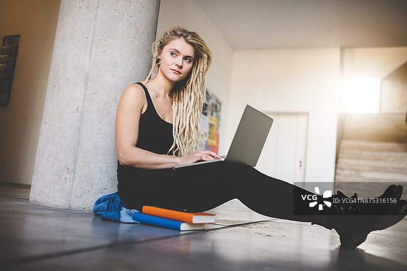 正在用笔记本电脑工作的纹身女人图片素材