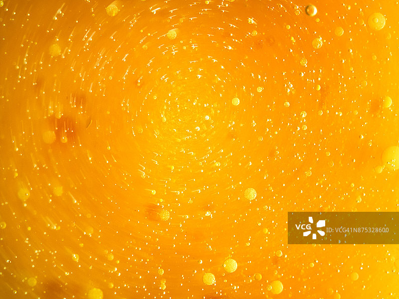 橙色液体背景上的抽象形状和纹理，形成漩涡图片素材