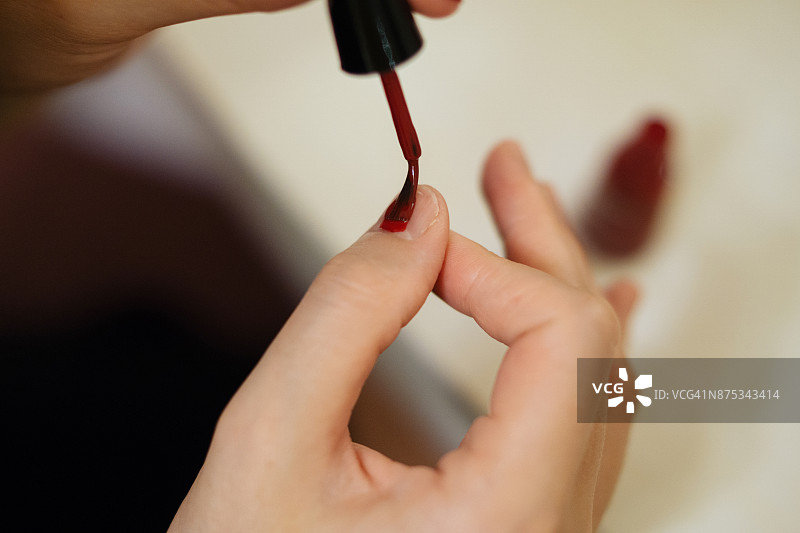 年轻女子涂指甲油图片素材