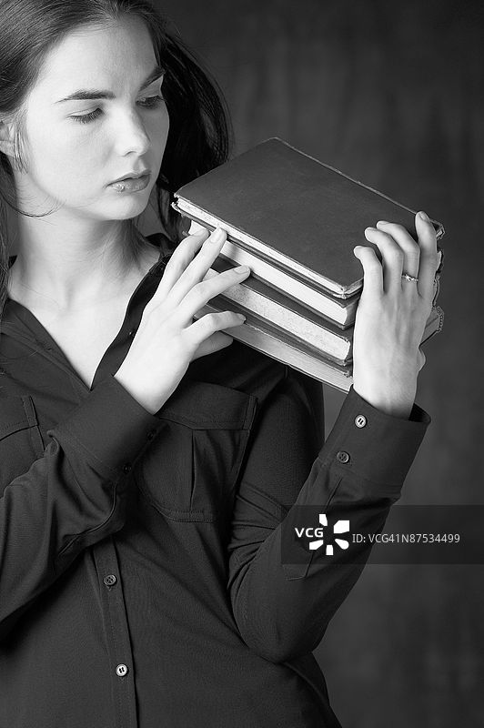 手握一堆书籍的女性图片素材