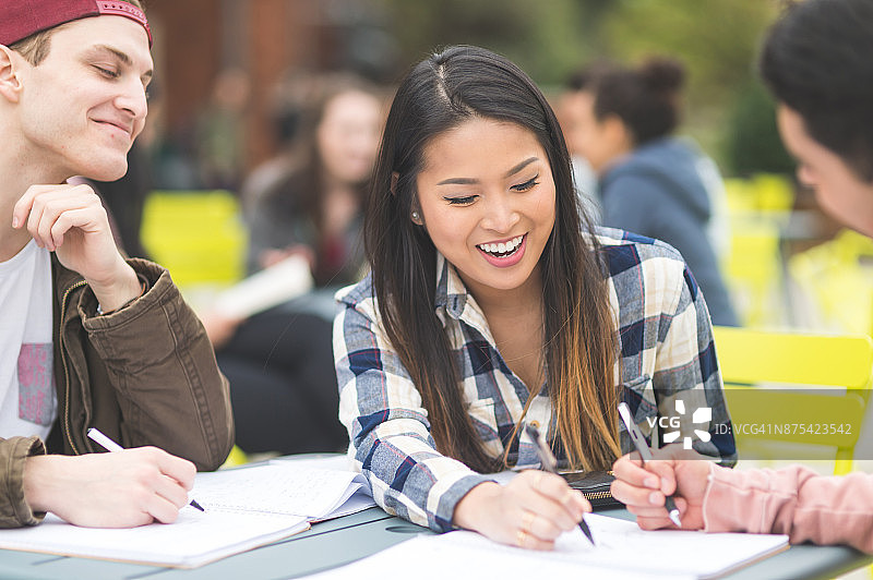 大学生在室外课桌旁一起学习图片素材