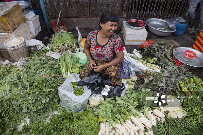 在缅甸仰光唐人街第18街市场卖蔬菜的快乐女人图片素材