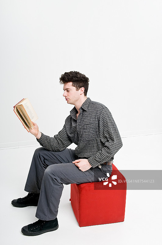 中年男人阅读书籍的影棚照图片素材