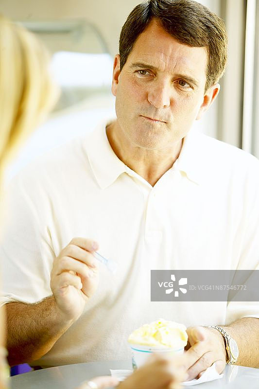 在商店里吃冰淇淋的男人图片素材