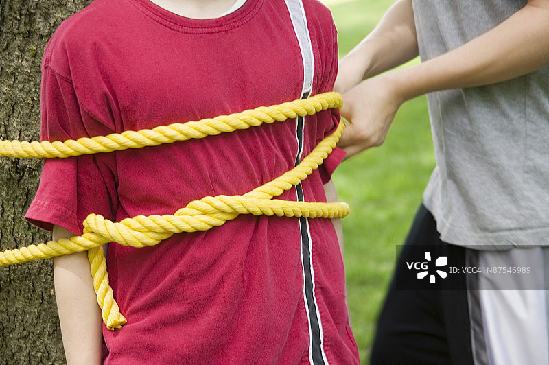 被绑在树上的男孩图片素材