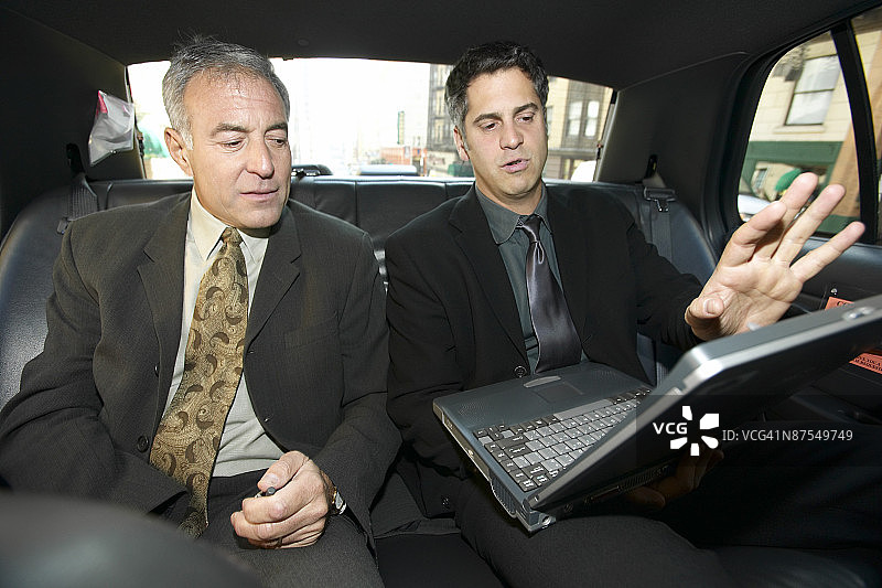 在汽车里使用笔记本电脑的商人们图片素材