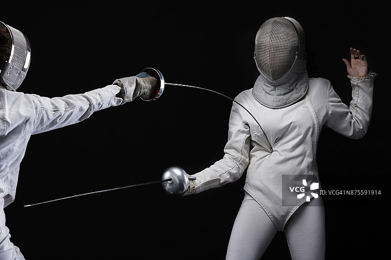 击剑运动比赛：决斗，黑色背景，运动女性图片素材