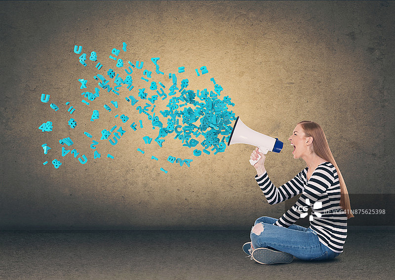 年轻女人对着扩音器尖叫图片素材