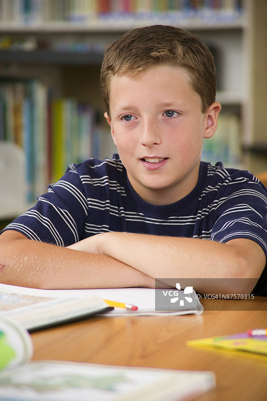 学生坐着，双臂交叉。图片素材