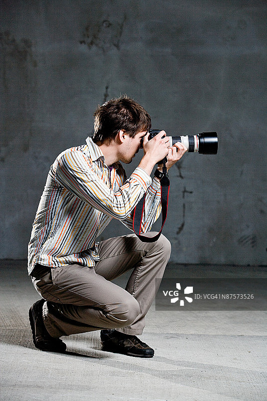 摄影师蹲伏拍摄的影棚照片图片素材