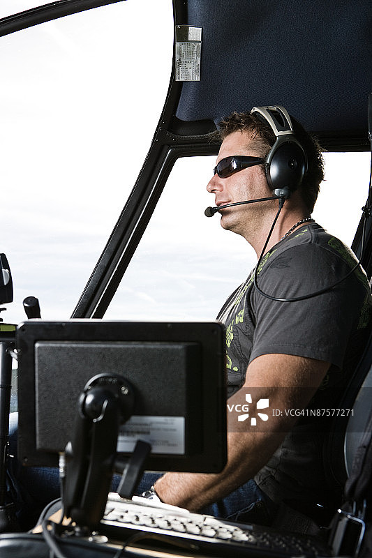 飞行员坐在直升机驾驶舱内图片素材
