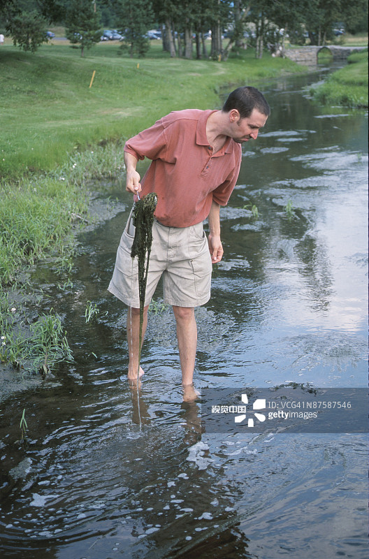 高尔夫球手在水与藻类俱乐部图片素材