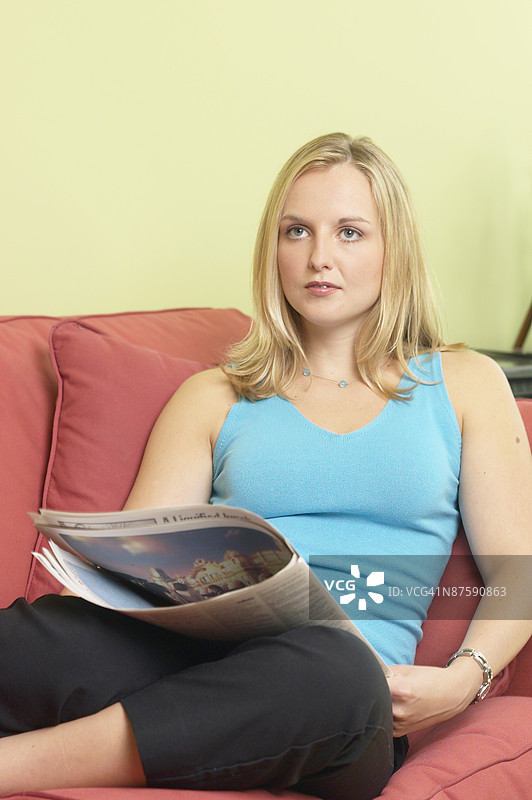 女人坐在沙发上看报纸图片素材