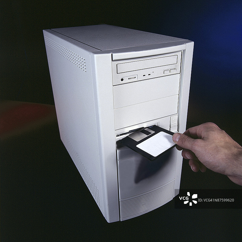 一个人将软盘插入电脑图片素材