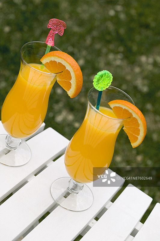 桌子上两杯用橙子装饰的饮料图片素材