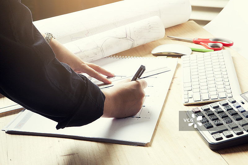 男建筑师在办公桌上绘制蓝图的手部特写图片素材