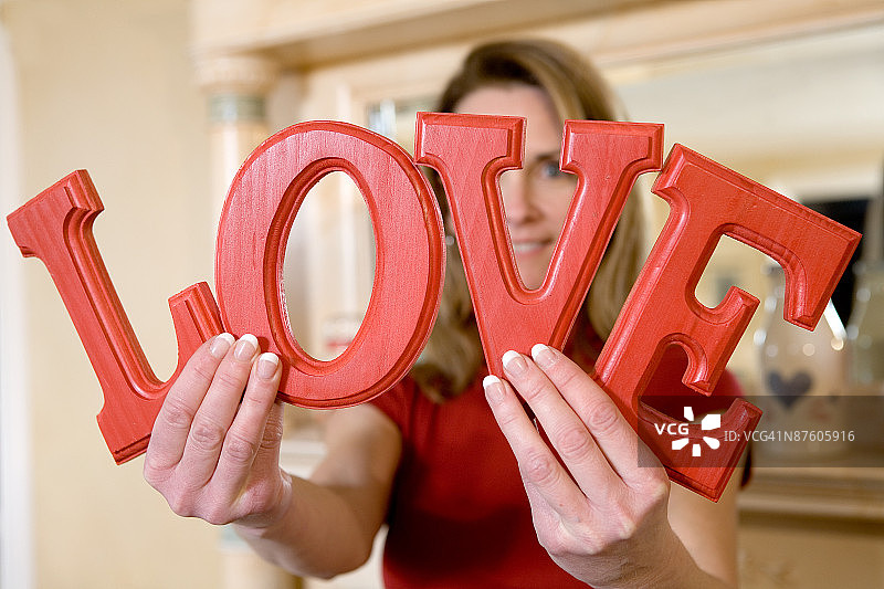 拿着拼出爱的字母的女人图片素材