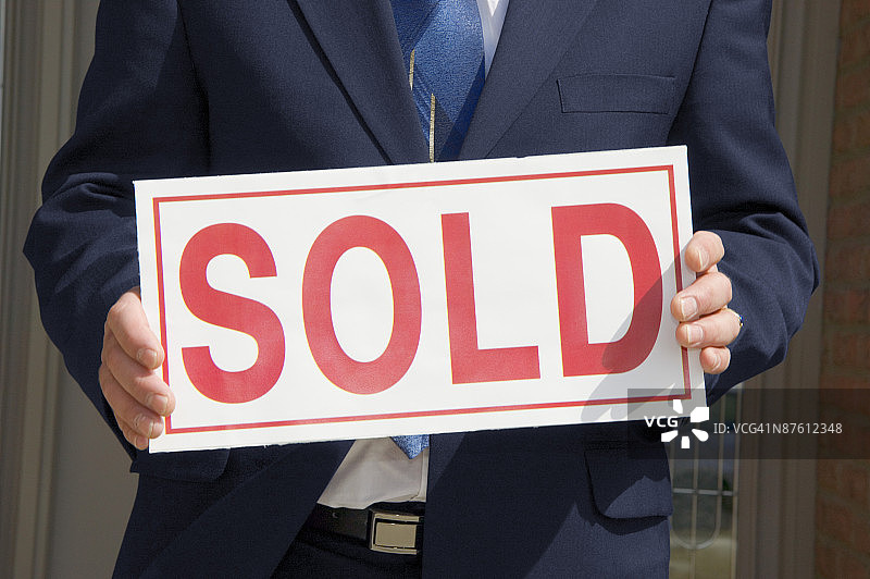 拿着房地产标志的商人图片素材