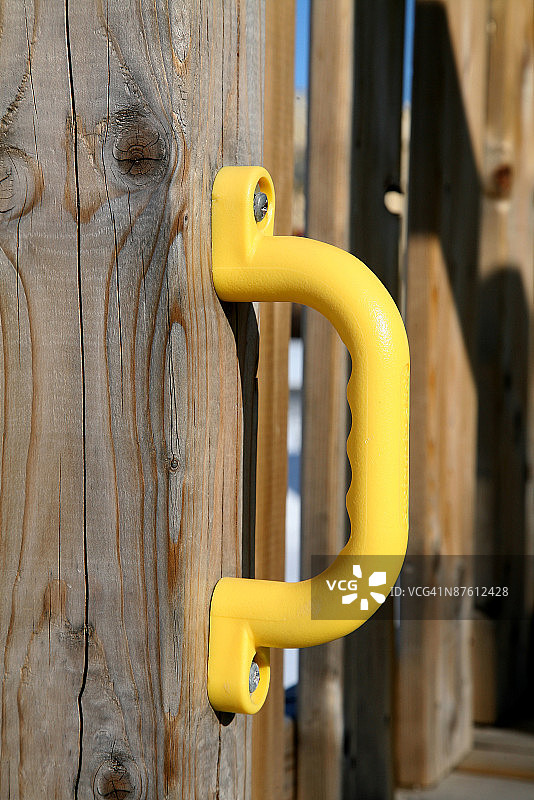 木栅栏门上的黄色塑料把手图片素材