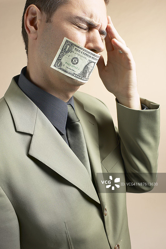 嘴边放钱的商人图片素材