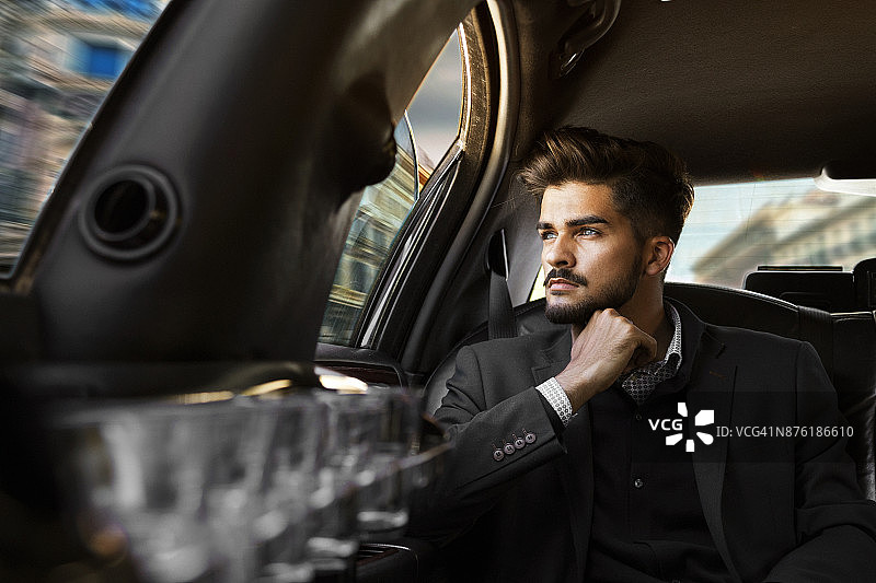 驾车穿梭于城市的年轻商人图片素材