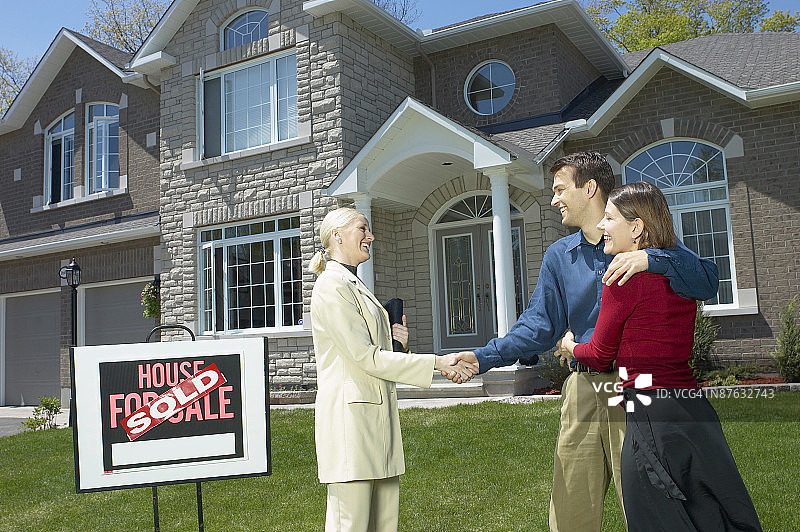 情侣与房地产经纪人握手图片素材